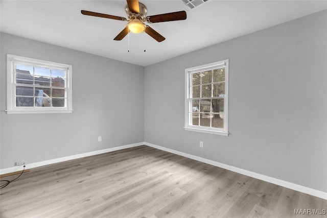 empty room featuring ceiling fan, light hardwood / wood-style floors, and a wealth of natural light