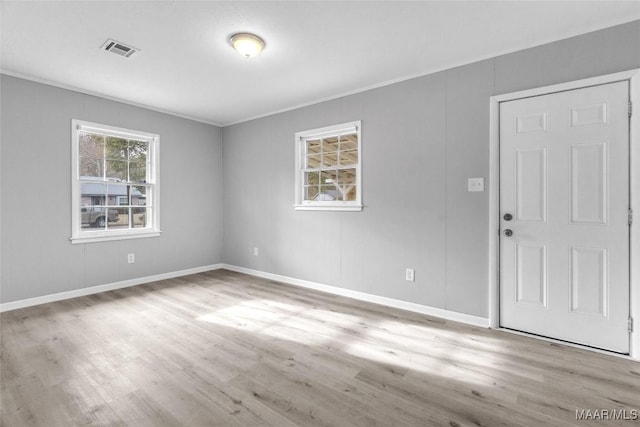 unfurnished room with light hardwood / wood-style floors and crown molding