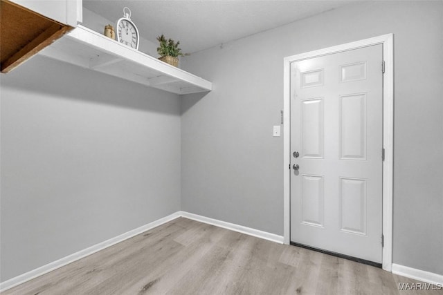 laundry area with light hardwood / wood-style floors