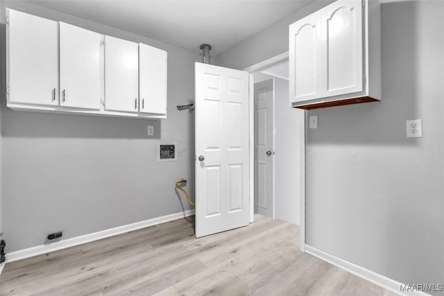 laundry room featuring cabinets, washer hookup, and light wood-type flooring