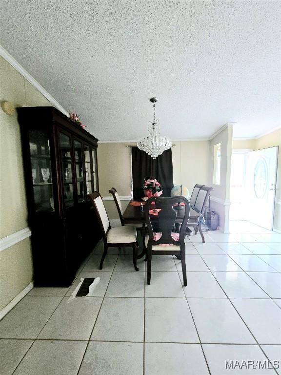 tiled dining space featuring a chandelier, a textured ceiling, and ornamental molding