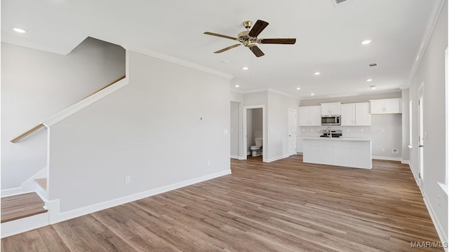 unfurnished living room featuring crown molding, light hardwood / wood-style flooring, and ceiling fan