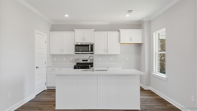 kitchen with a center island with sink, white cabinets, and stainless steel appliances