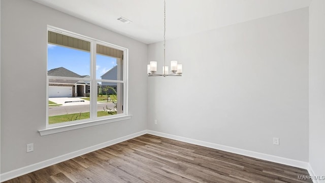 unfurnished dining area featuring hardwood / wood-style flooring and a notable chandelier