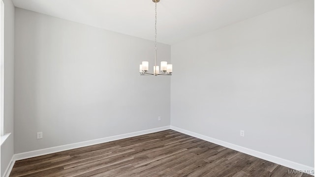 unfurnished room featuring dark hardwood / wood-style floors and a notable chandelier