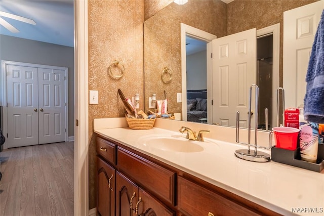 bathroom featuring ceiling fan, vanity, and wood-type flooring