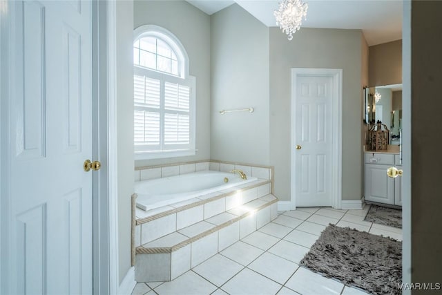 bathroom featuring tile patterned floors, plenty of natural light, tiled tub, and a chandelier