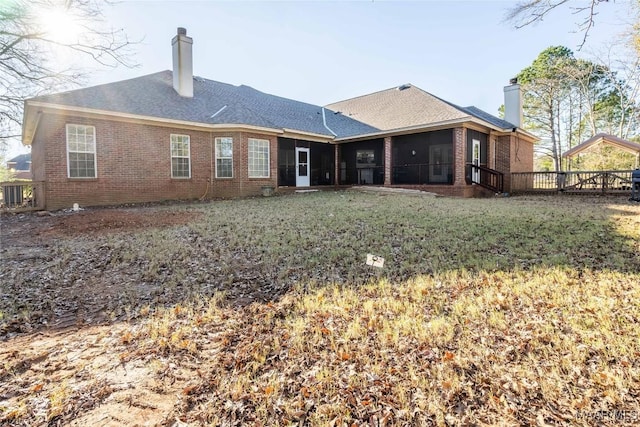 back of house featuring a yard and a sunroom