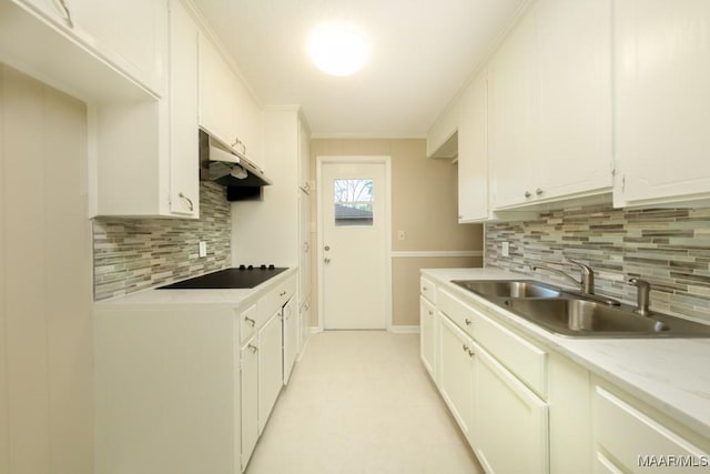 kitchen with decorative backsplash, sink, white cabinets, and black electric stovetop