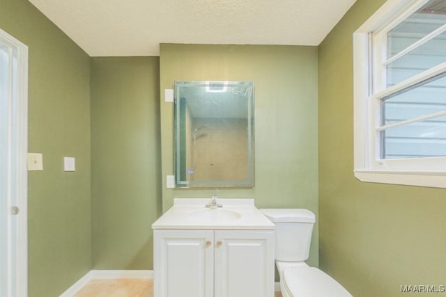 bathroom featuring a textured ceiling, vanity, and toilet