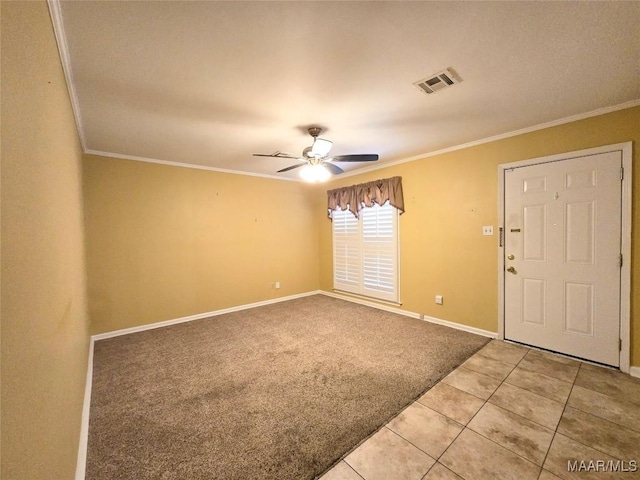 foyer entrance featuring ceiling fan, crown molding, and carpet