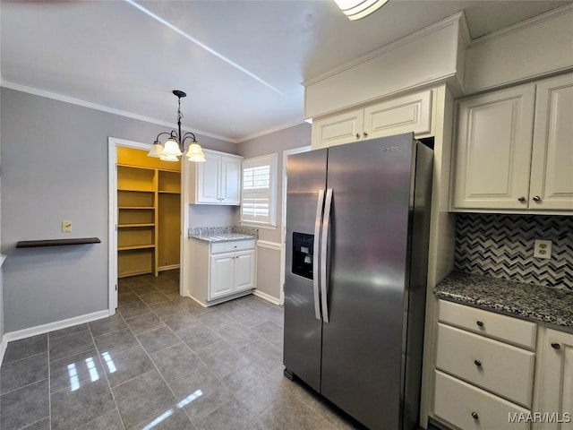 kitchen with pendant lighting, backsplash, stainless steel refrigerator with ice dispenser, dark stone countertops, and a notable chandelier