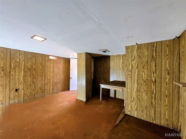 interior space featuring wood walls and dark carpet