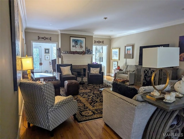 living room featuring crown molding, hardwood / wood-style floors, and a brick fireplace