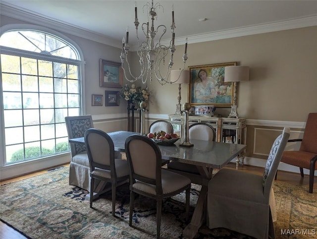 dining room featuring hardwood / wood-style floors, ornamental molding, and an inviting chandelier