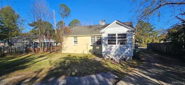 rear view of house featuring a lawn