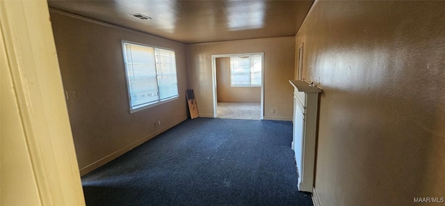 unfurnished room featuring dark colored carpet