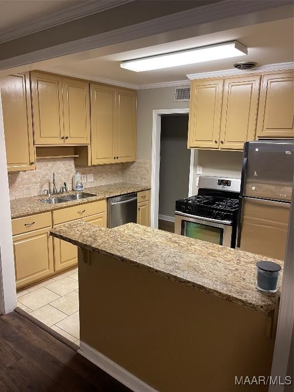 kitchen featuring crown molding, light hardwood / wood-style flooring, stainless steel appliances, and sink