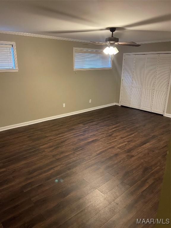 unfurnished bedroom with a closet, ceiling fan, crown molding, and dark hardwood / wood-style floors