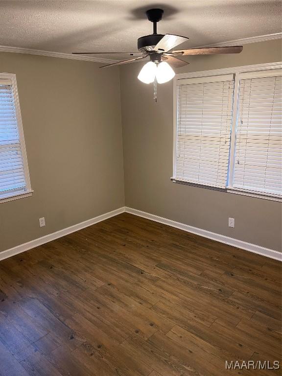 spare room featuring dark hardwood / wood-style flooring, ornamental molding, and a textured ceiling