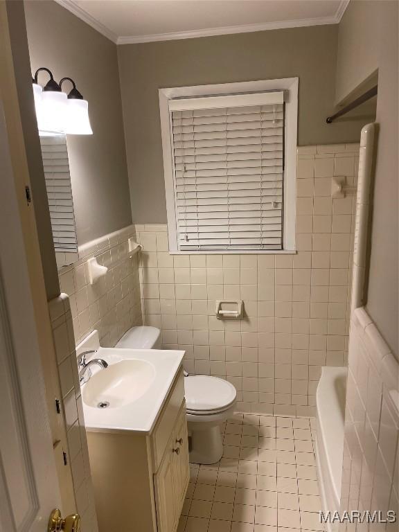 full bathroom featuring vanity, crown molding, tile walls, tile patterned flooring, and toilet