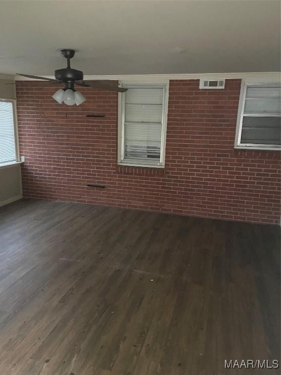 exterior space with dark hardwood / wood-style floors, ceiling fan, and brick wall