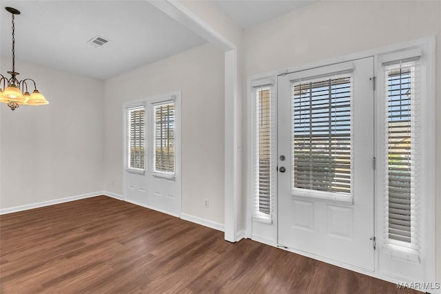 entrance foyer featuring dark hardwood / wood-style flooring and a notable chandelier