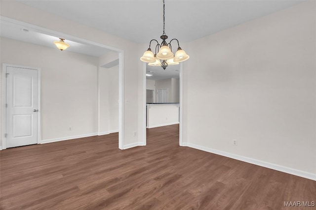 unfurnished dining area with dark hardwood / wood-style flooring and an inviting chandelier