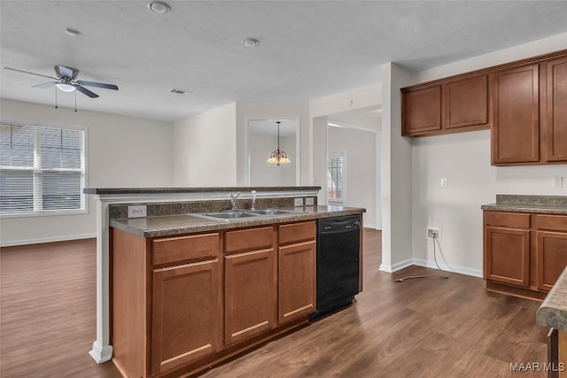 kitchen with ceiling fan with notable chandelier, sink, hanging light fixtures, black dishwasher, and dark hardwood / wood-style flooring