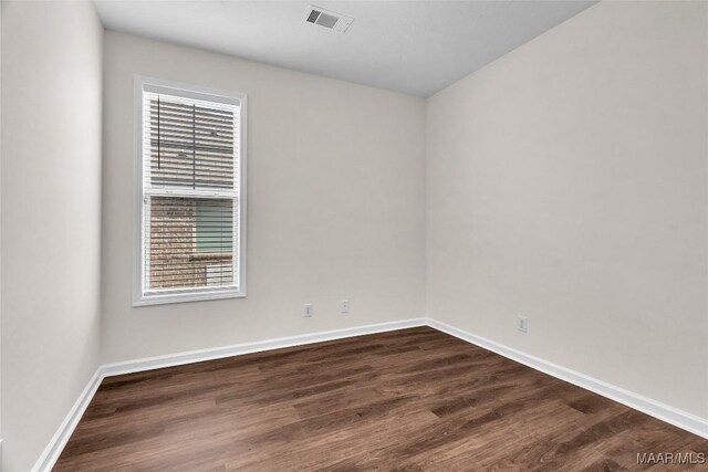 empty room with dark hardwood / wood-style flooring