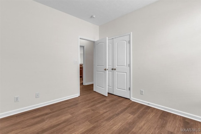 unfurnished bedroom featuring a closet and hardwood / wood-style floors