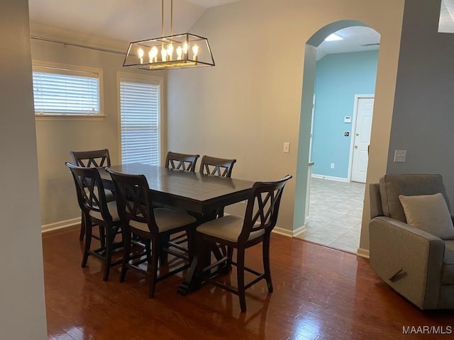 dining area featuring wood-type flooring and vaulted ceiling