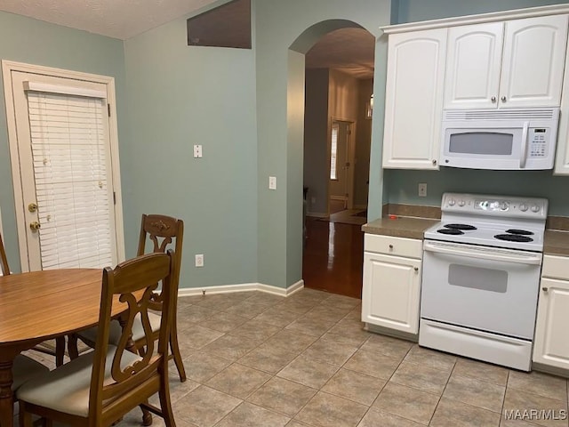 kitchen featuring white cabinets, white appliances, and light tile patterned floors