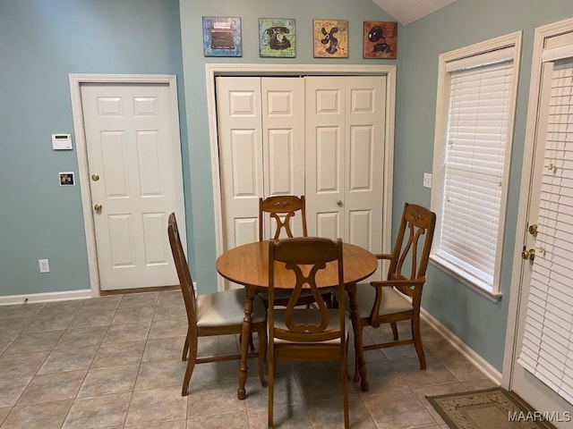 dining room featuring light tile patterned flooring, lofted ceiling, and a wealth of natural light