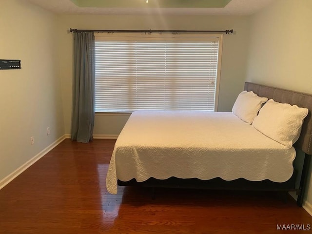 bedroom with dark wood-type flooring