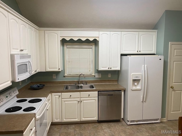 kitchen featuring white appliances, a textured ceiling, sink, light tile patterned floors, and white cabinets