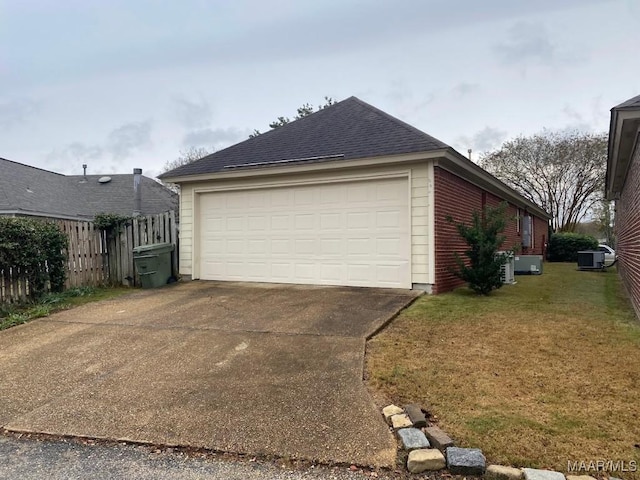 view of side of home featuring a lawn, central AC unit, and a garage