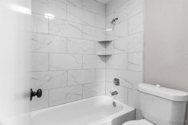 bathroom with tiled shower / bath combo and toilet