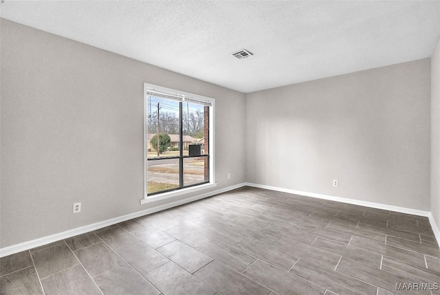 spare room with a textured ceiling