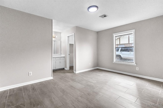 spare room with a textured ceiling and hardwood / wood-style flooring