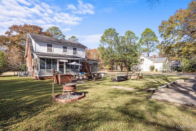 back of house featuring a lawn and a sunroom