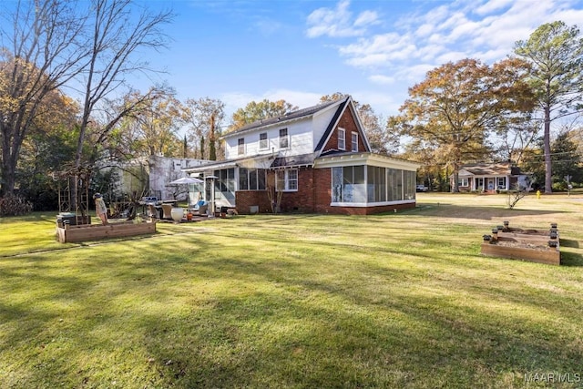 back of property featuring a yard and a sunroom