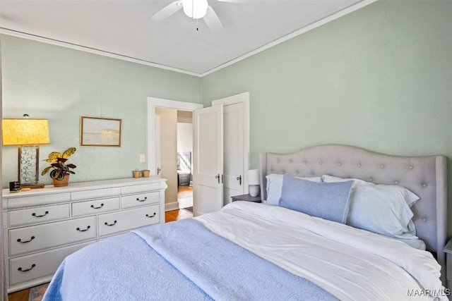 bedroom featuring ceiling fan, wood-type flooring, and crown molding