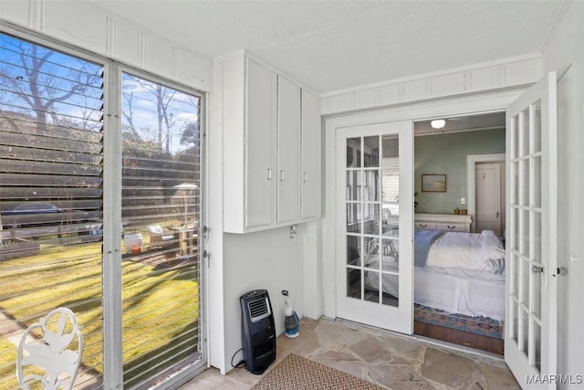 entryway featuring heating unit, a textured ceiling, and french doors