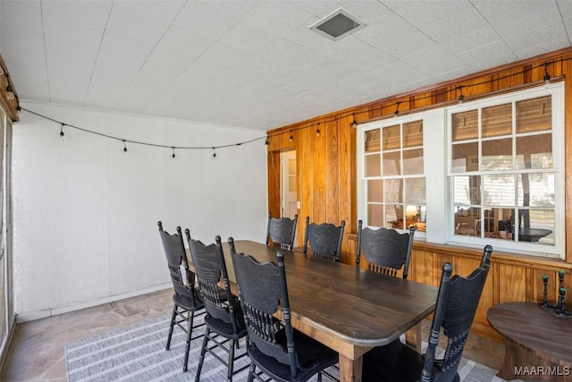 dining room featuring wood walls