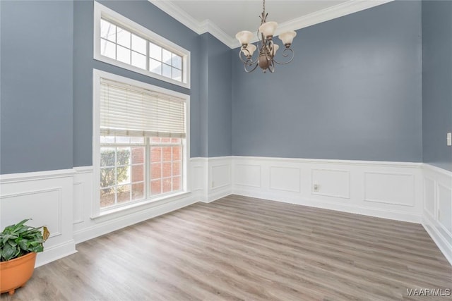 spare room with hardwood / wood-style flooring, a notable chandelier, and crown molding