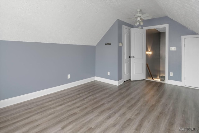 additional living space featuring hardwood / wood-style floors, ceiling fan, lofted ceiling, and a textured ceiling