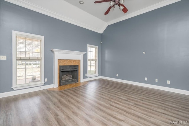 unfurnished living room with hardwood / wood-style flooring, ceiling fan, ornamental molding, and a tile fireplace