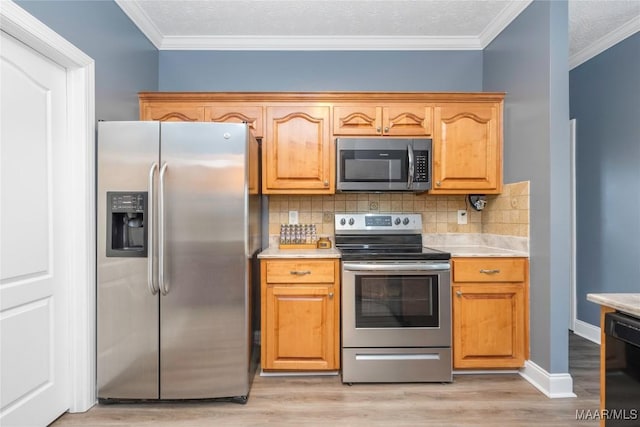 kitchen with decorative backsplash, light wood-type flooring, ornamental molding, and appliances with stainless steel finishes