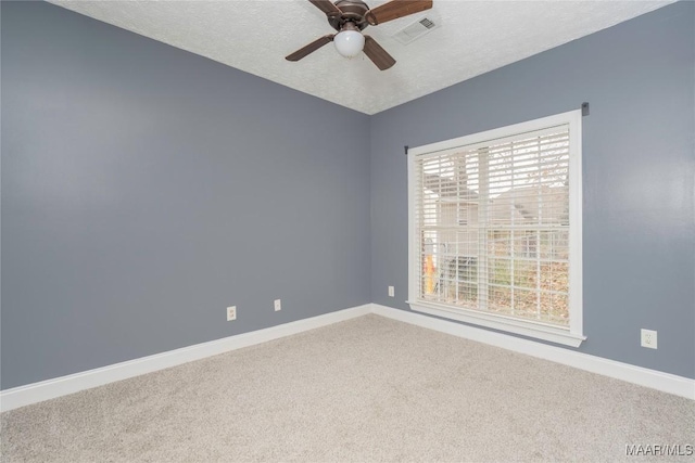 carpeted spare room with ceiling fan and a textured ceiling